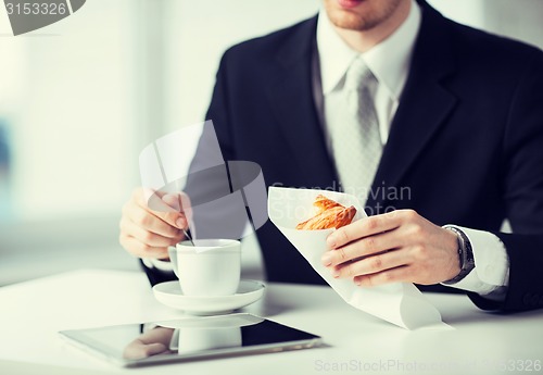 Image of man with tablet pc and cup of coffee