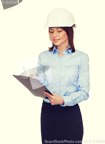 Image of smiling businesswoman in helmet with clipboard