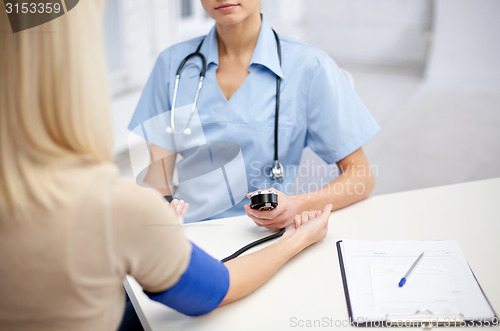 Image of close up of doctor and woman measuring pressure