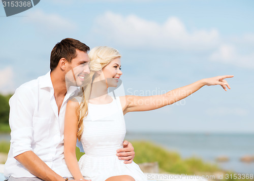 Image of couple sitting at sea side