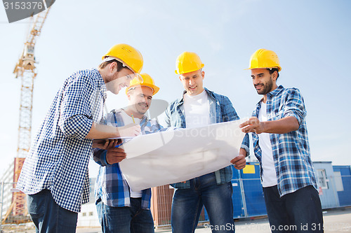 Image of group of builders with tablet pc and blueprint