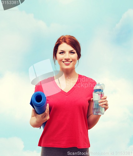 Image of smiling girl with bottle of water after exercising