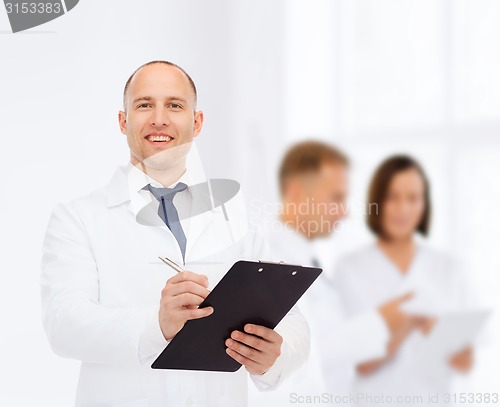 Image of smiling male doctor with clipboard