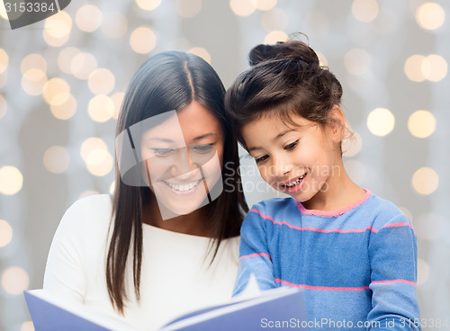 Image of happy mother and daughter reading book