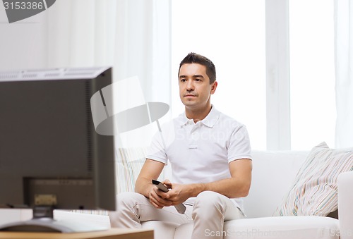 Image of man with remote control watching tv