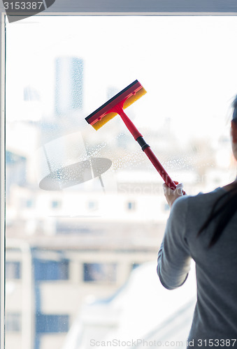 Image of close up of woman cleaning window with sponge