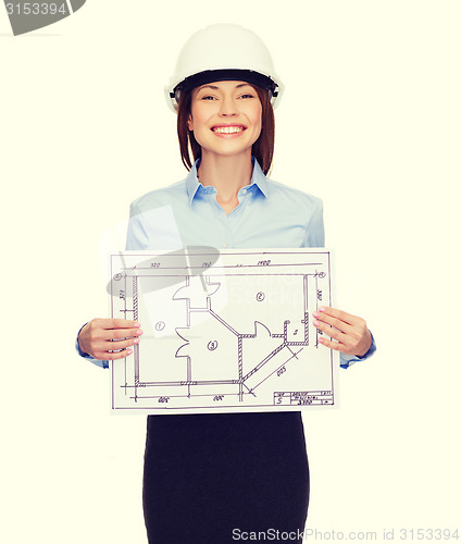 Image of smiling businesswoman in helmet showing blueprint