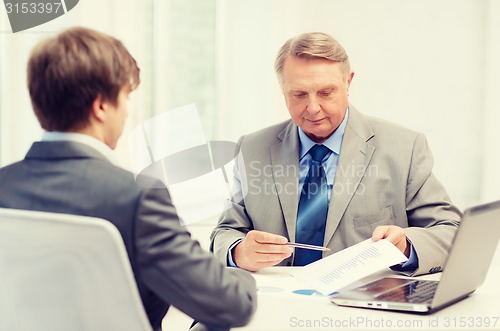 Image of older man and young man having meeting in office