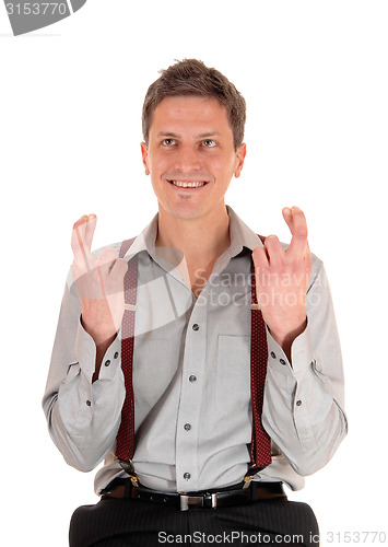 Image of Smiling man crossing fingers