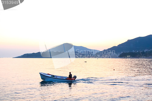 Image of Scenic view at sea with fishman in boat