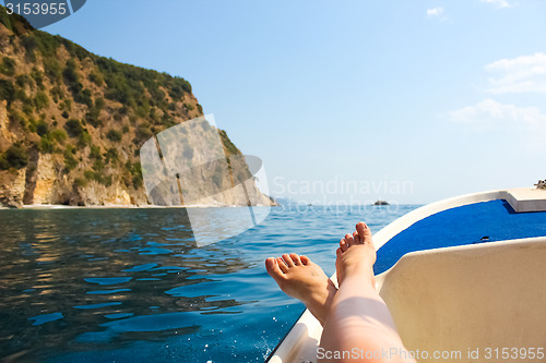 Image of woman lounging on a catamaran sailboat