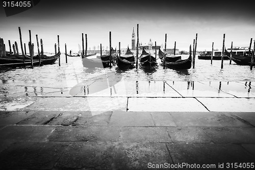 Image of Gondolas moored in front of pavement bw