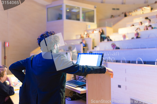 Image of Speaker giving talk on podium at Business Conference.