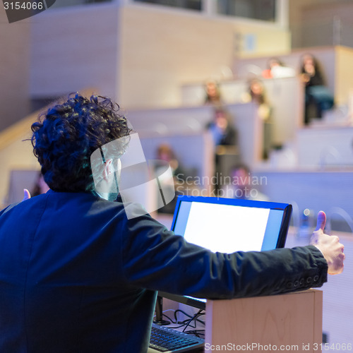 Image of Speaker giving talk on podium at Business Conference.