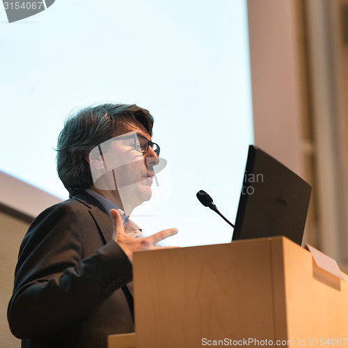 Image of Speaker giving talk on podium at Business Conference.