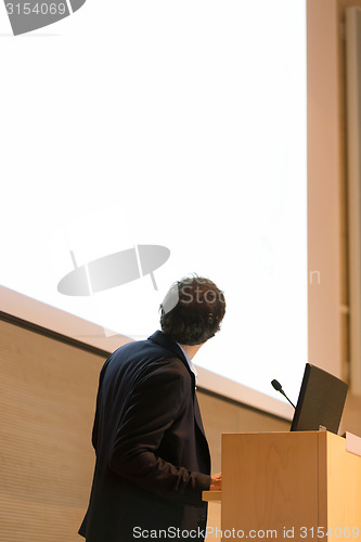 Image of Speaker giving talk on podium at Business Conference.