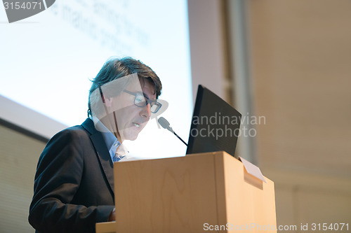 Image of Speaker giving talk on podium at Business Conference.