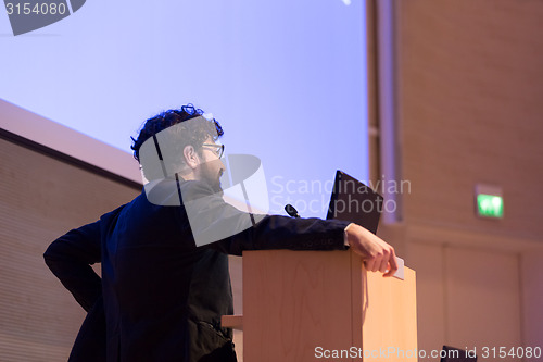 Image of Speaker giving talk on podium at Business Conference.