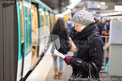 Image of Lady waiting on subway station platform.