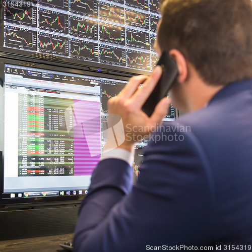 Image of Stock trader looking at computer screens.