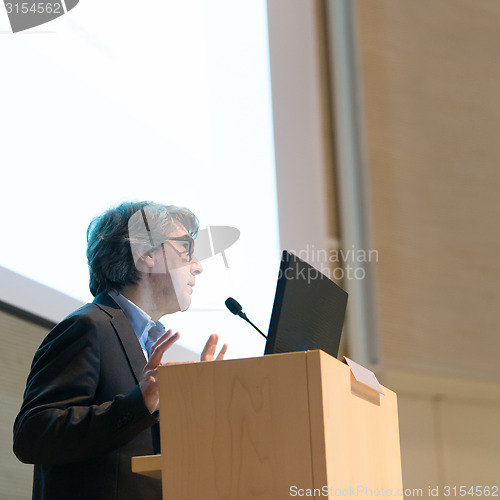 Image of Speaker giving talk on podium at Business Conference.