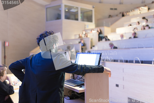 Image of Speaker giving talk on podium at Business Conference.