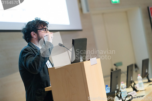 Image of Speaker giving talk on podium at Business Conference.