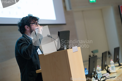 Image of Speaker giving talk on podium at Business Conference.