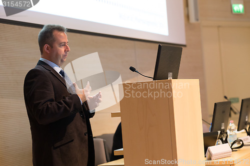 Image of Speaker giving talk on podium at Business Conference.