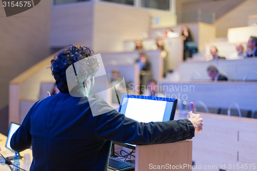 Image of Speaker giving talk on podium at Business Conference.