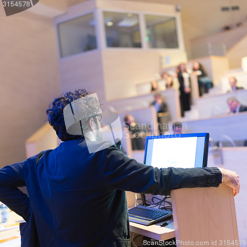 Image of Speaker giving talk on podium at Business Conference.