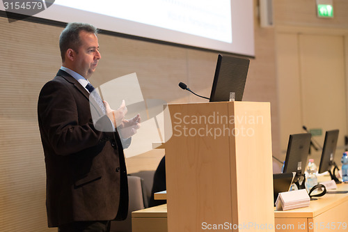 Image of Speaker giving talk on podium at Business Conference.