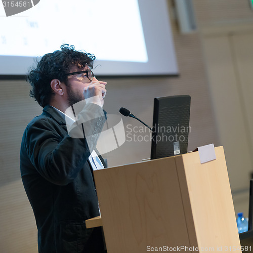 Image of Speaker giving talk on podium at Business Conference.