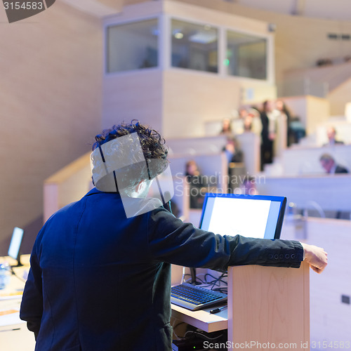 Image of Speaker giving talk on podium at Business Conference.