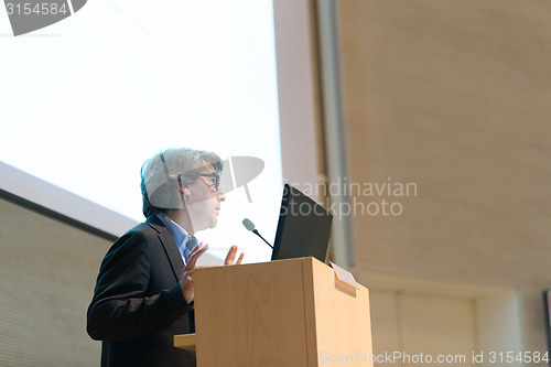 Image of Speaker giving talk on podium at Business Conference.