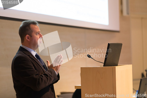 Image of Speaker giving talk on podium at Business Conference.