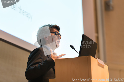 Image of Speaker giving talk on podium at Business Conference.