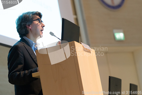 Image of Speaker giving talk on podium at Business Conference.