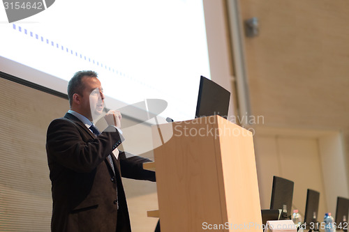 Image of Speaker giving talk on podium at Business Conference.