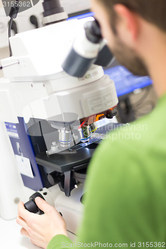 Image of Scientist microscoping on fluorescent microscope. 