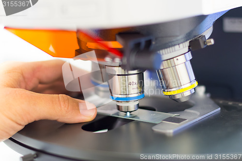 Image of Scientist microscoping on fluorescent microscope. 