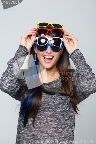 Image of Smiling woman wearing many colourful sunglasses