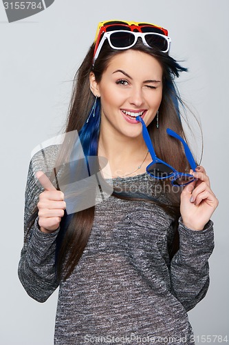 Image of Smiling woman wearing many colourful sunglasses