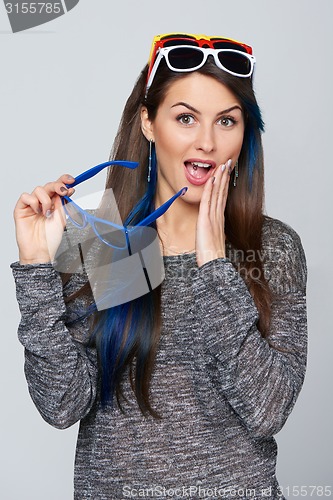 Image of Smiling woman wearing many colourful sunglasses