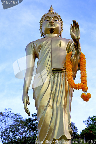 Image of siddharta   in the temple bangkok asia  orange flower