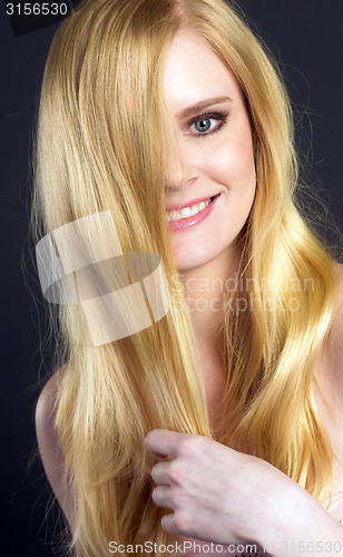 Image of Beautiful Smiling Blond Woman Grooming Brushing Her Hair