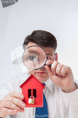 Image of Man with a magnifying glass and paper house