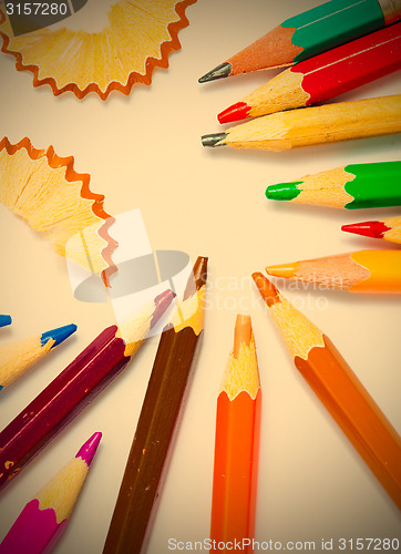 Image of several colored pencils and shavings on white background
