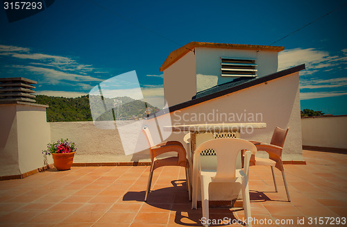 Image of table and chairs on the roof under the open sky