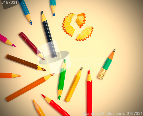 Image of several colored pencils and shavings on white background with co